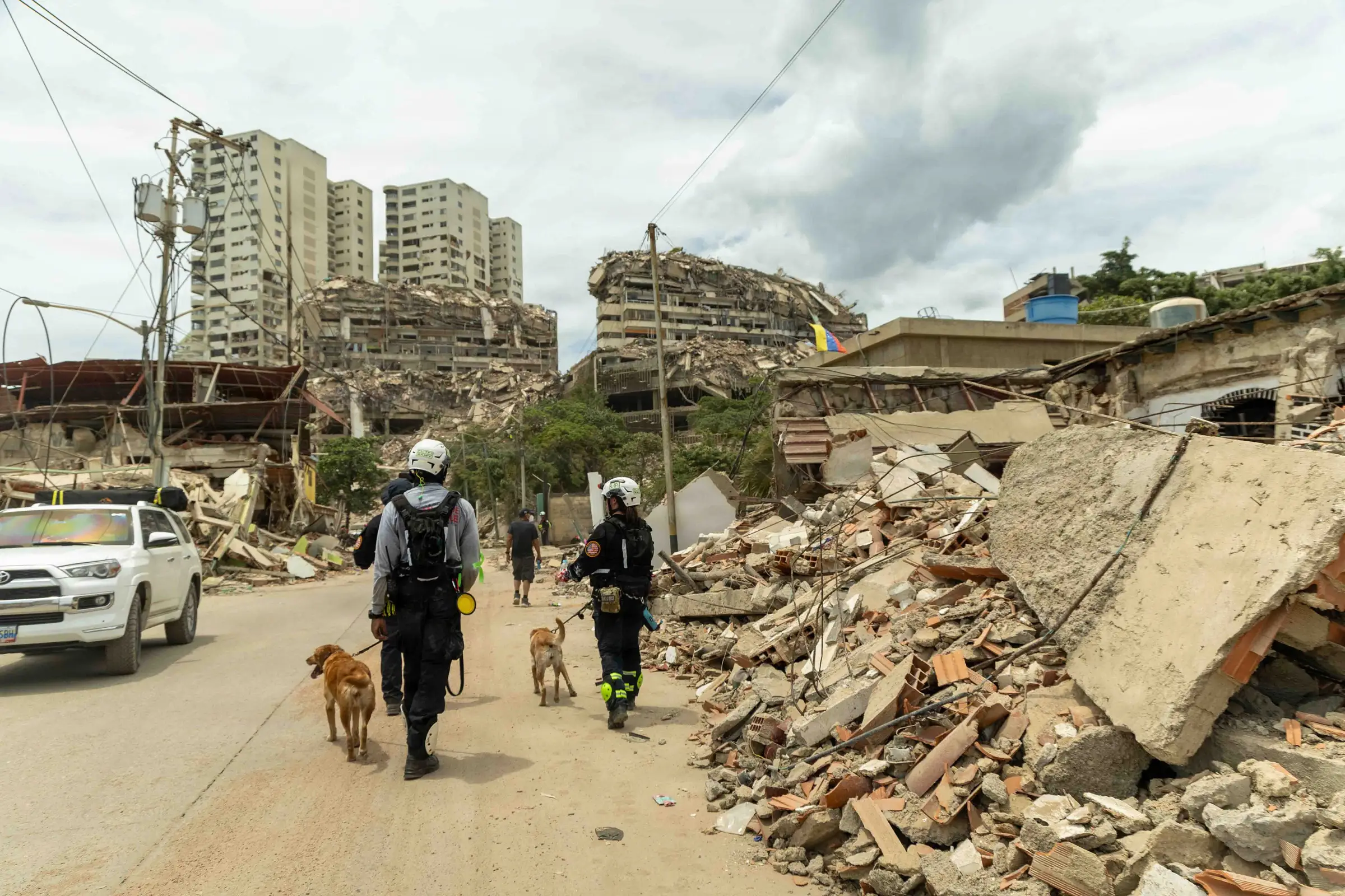 Search and rescue teams walking through earthquake damage in La Guaira, Venezuela